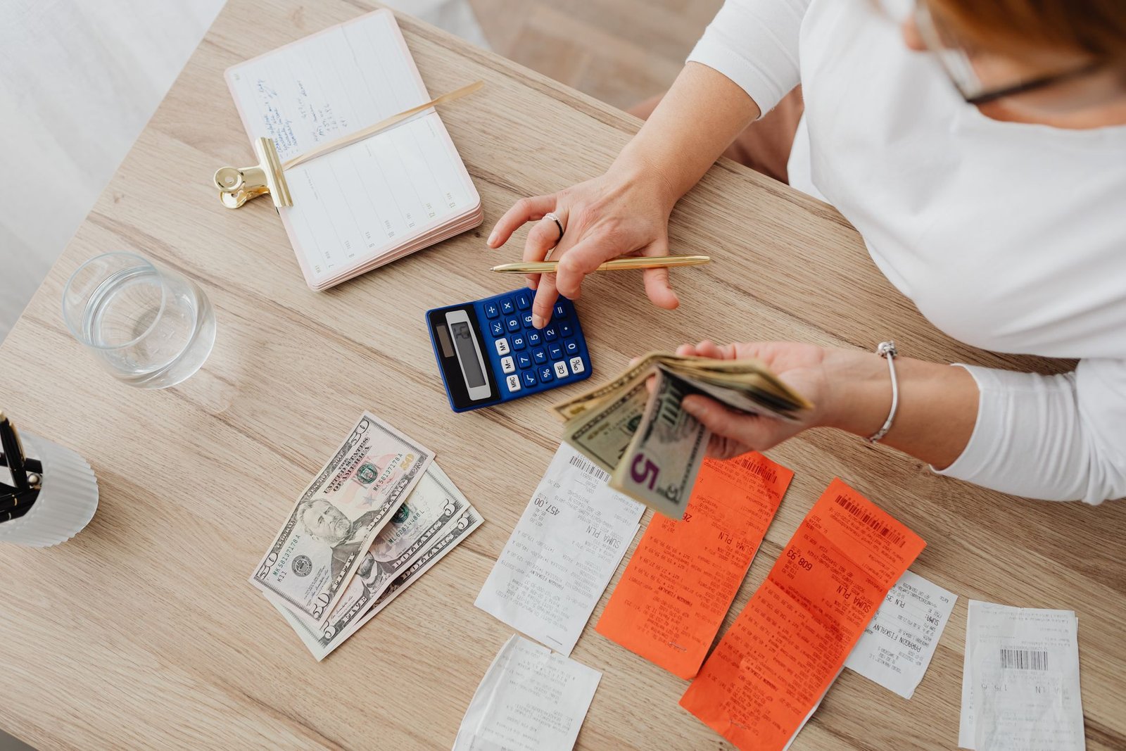 A person reviewing bills with a calculator at home