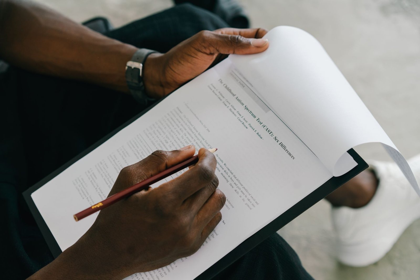 Person signing loan paperwork with a pen