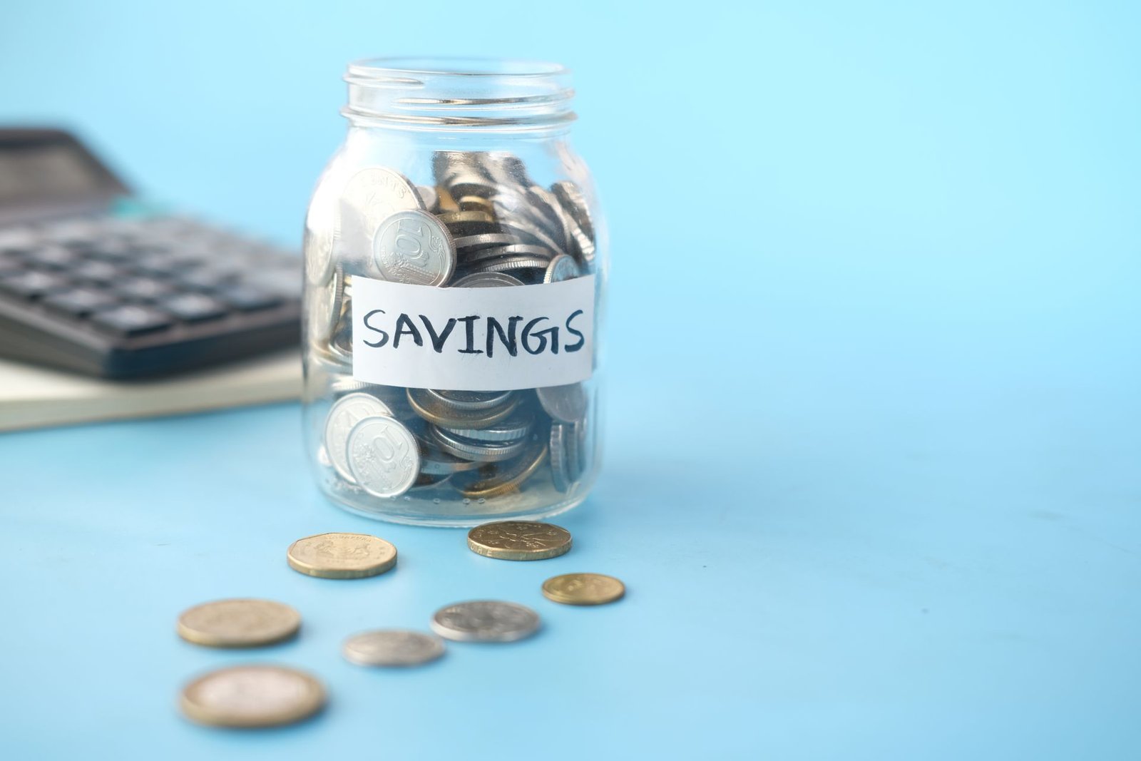 Glass jar filled with savings coins