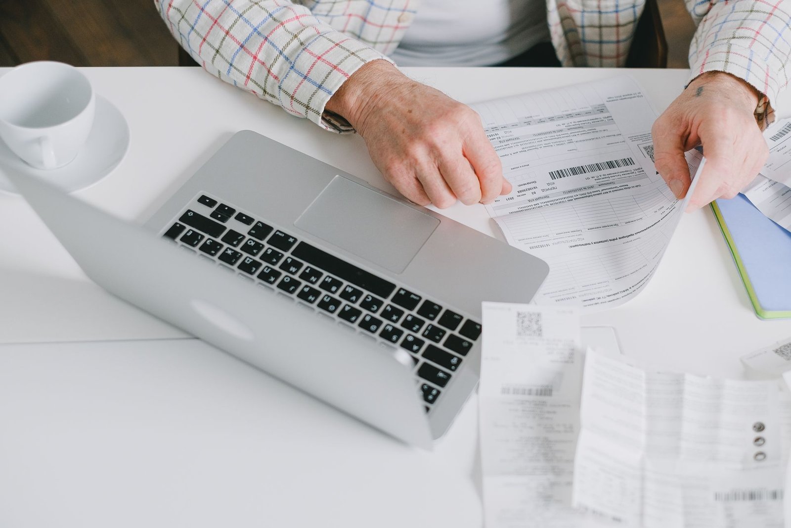 A person paying bills with paperwork at a desk