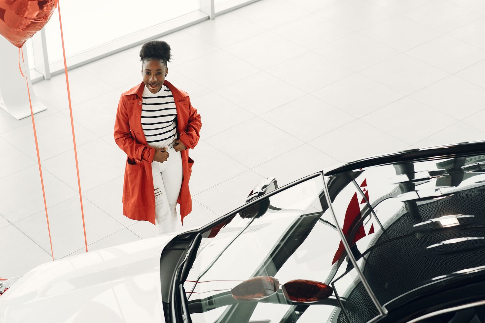 Woman looking at a car in a dealership showroom
