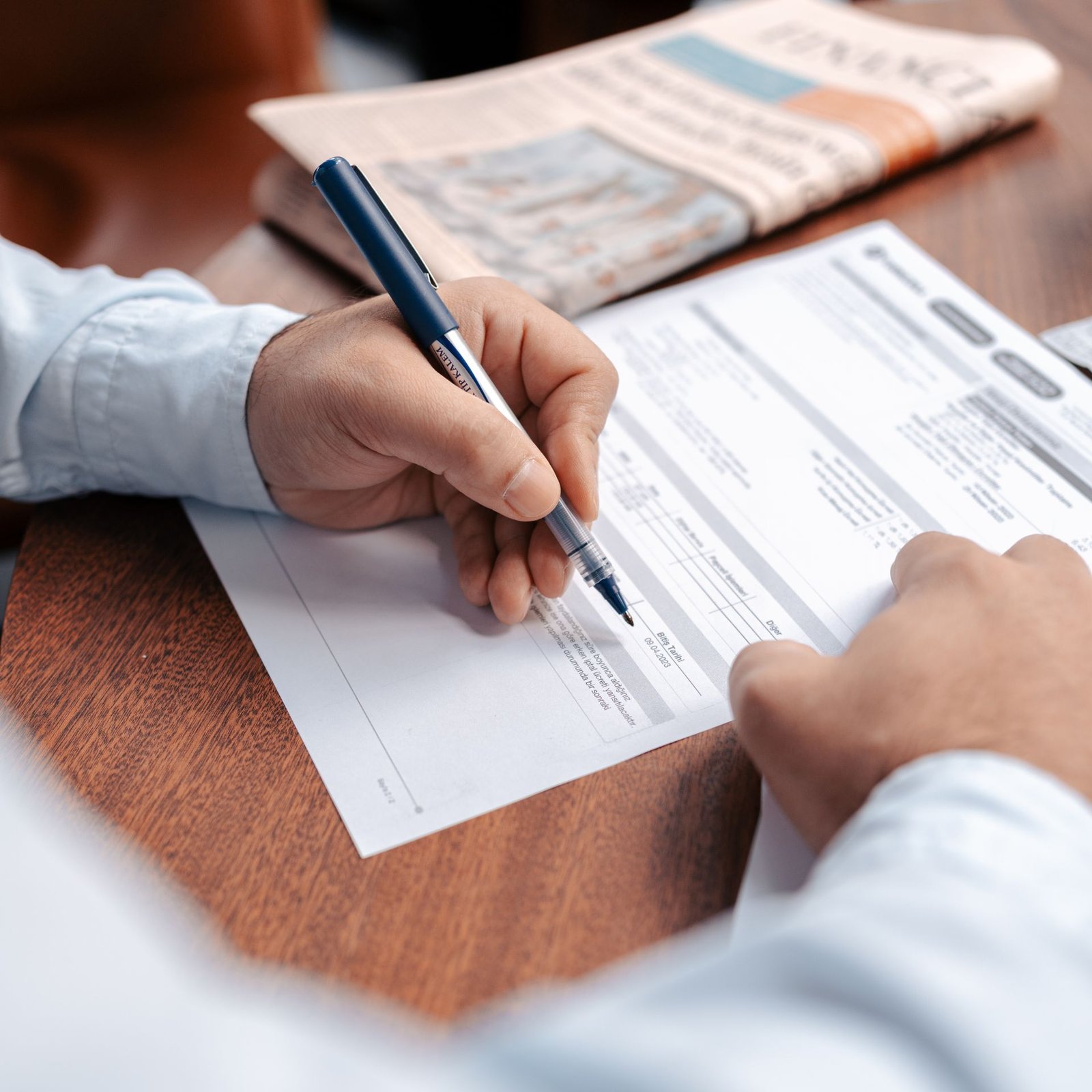 Person signing personal loan paperwork with a pen