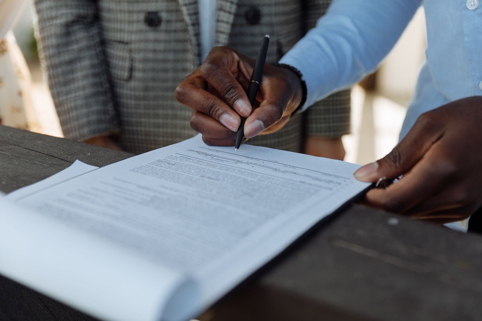 Hand signing a contract document with a pen