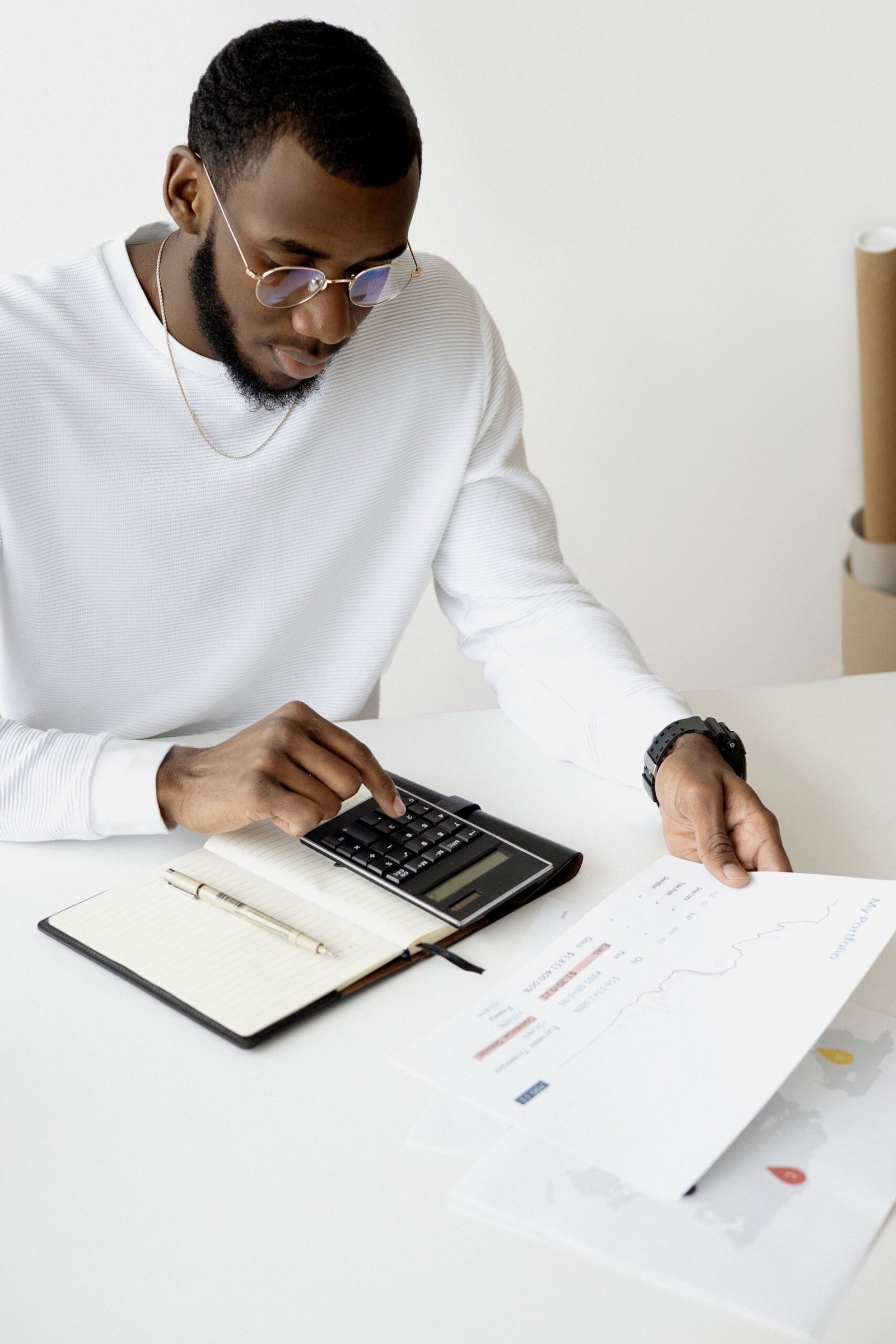 A person using a calculator and laptop for finances