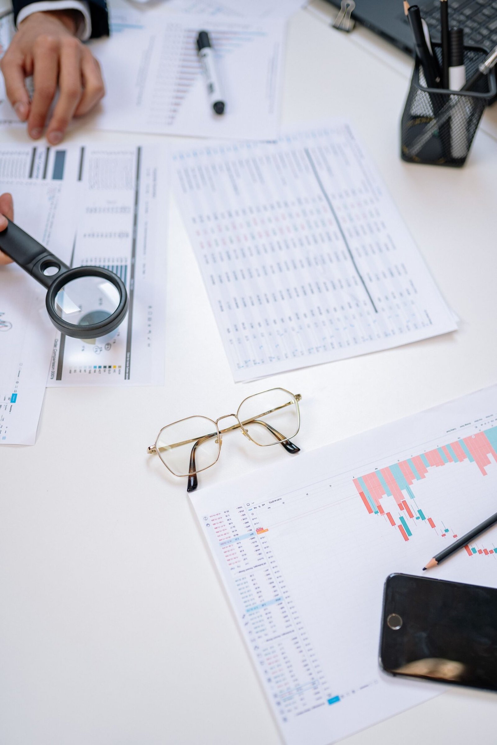 Magnifying glass examining financial documents up close
