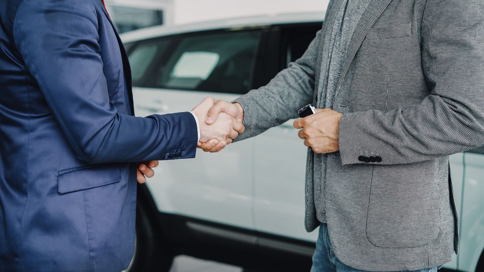 Car buyer shaking hands with a dealer at a dealership